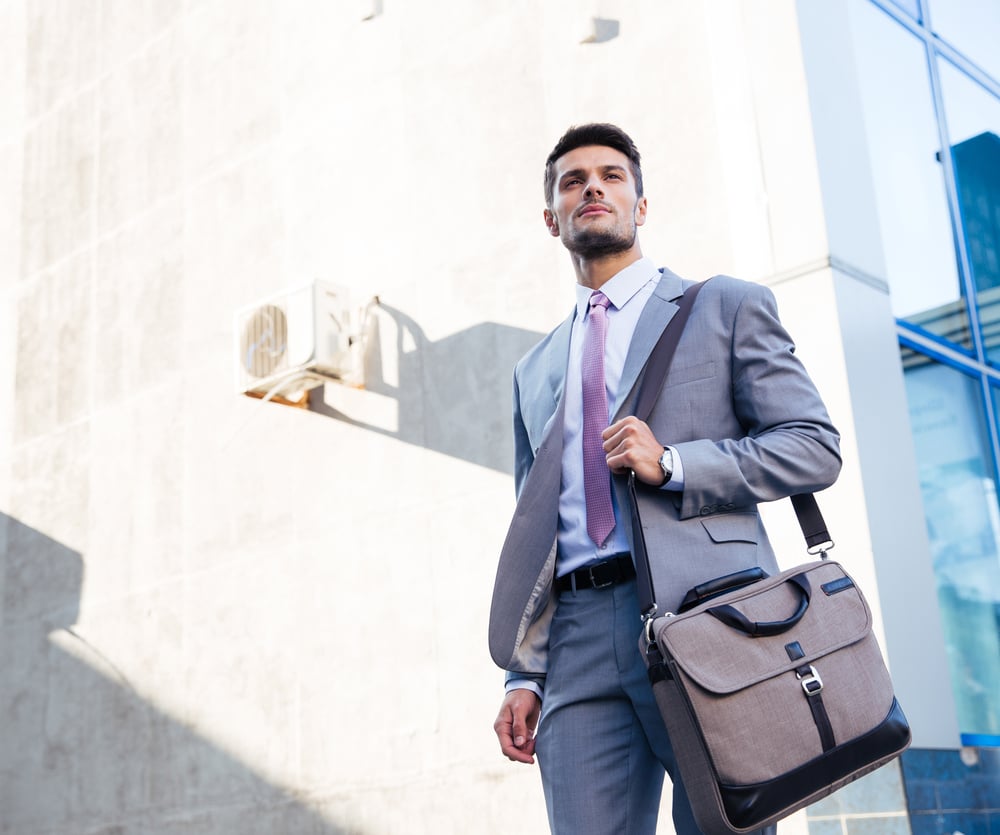 Portrait of a handsome businessman standing outdoors near office building